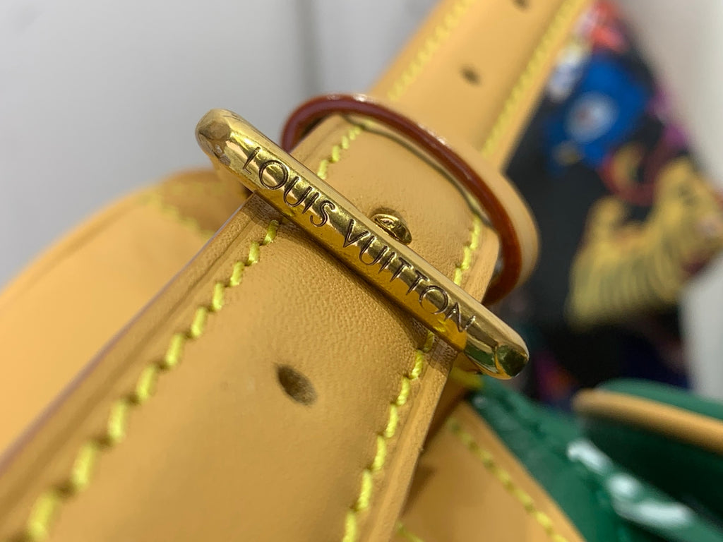 Louis Vuitton logo metal tab on yellow leather bag strap with stitching