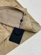 Beige Louis Vuitton jacket with zip pocket and hanging leather tag