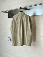 Beige short-sleeve utility jacket, back view with yoke seam and center zipper
