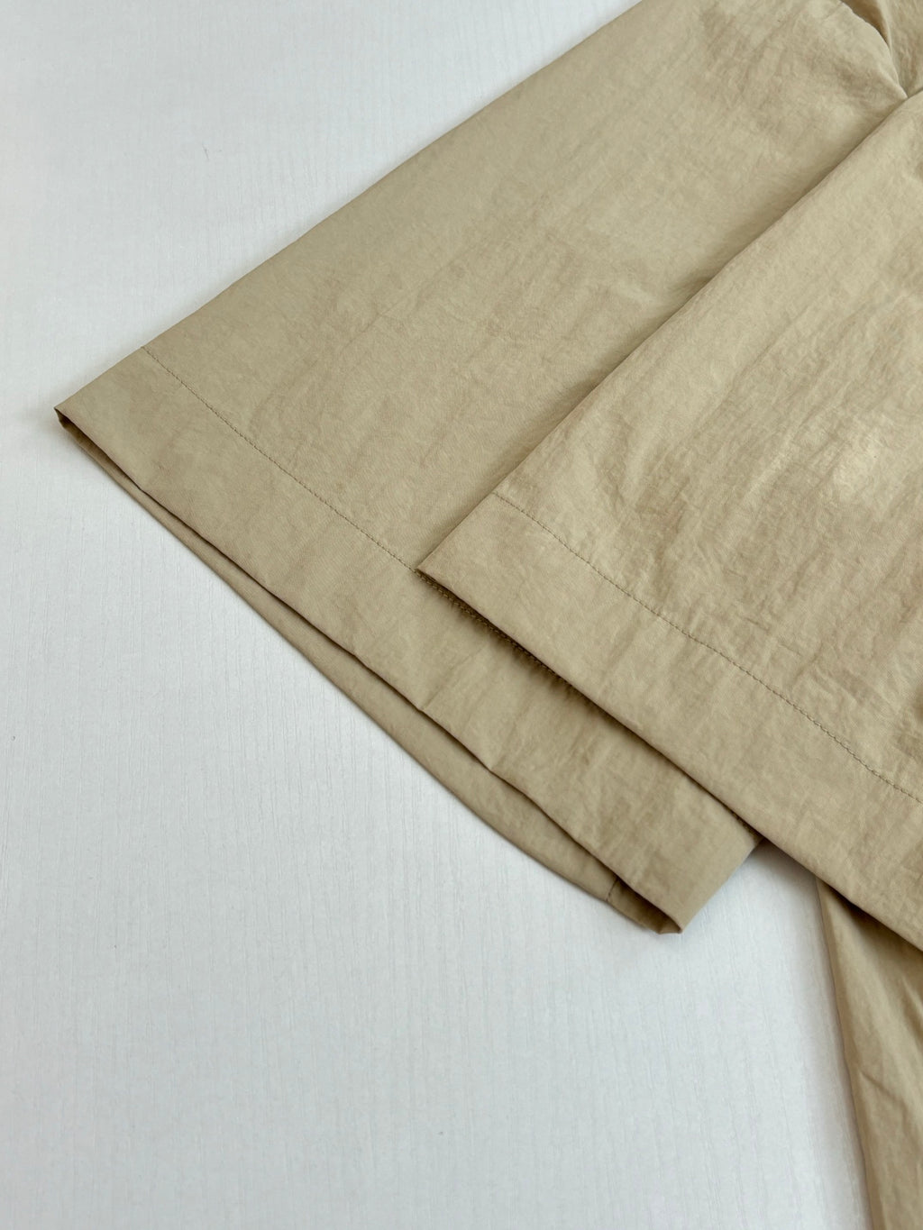 Folded beige Louis Vuitton shorts with straight leg and waistband