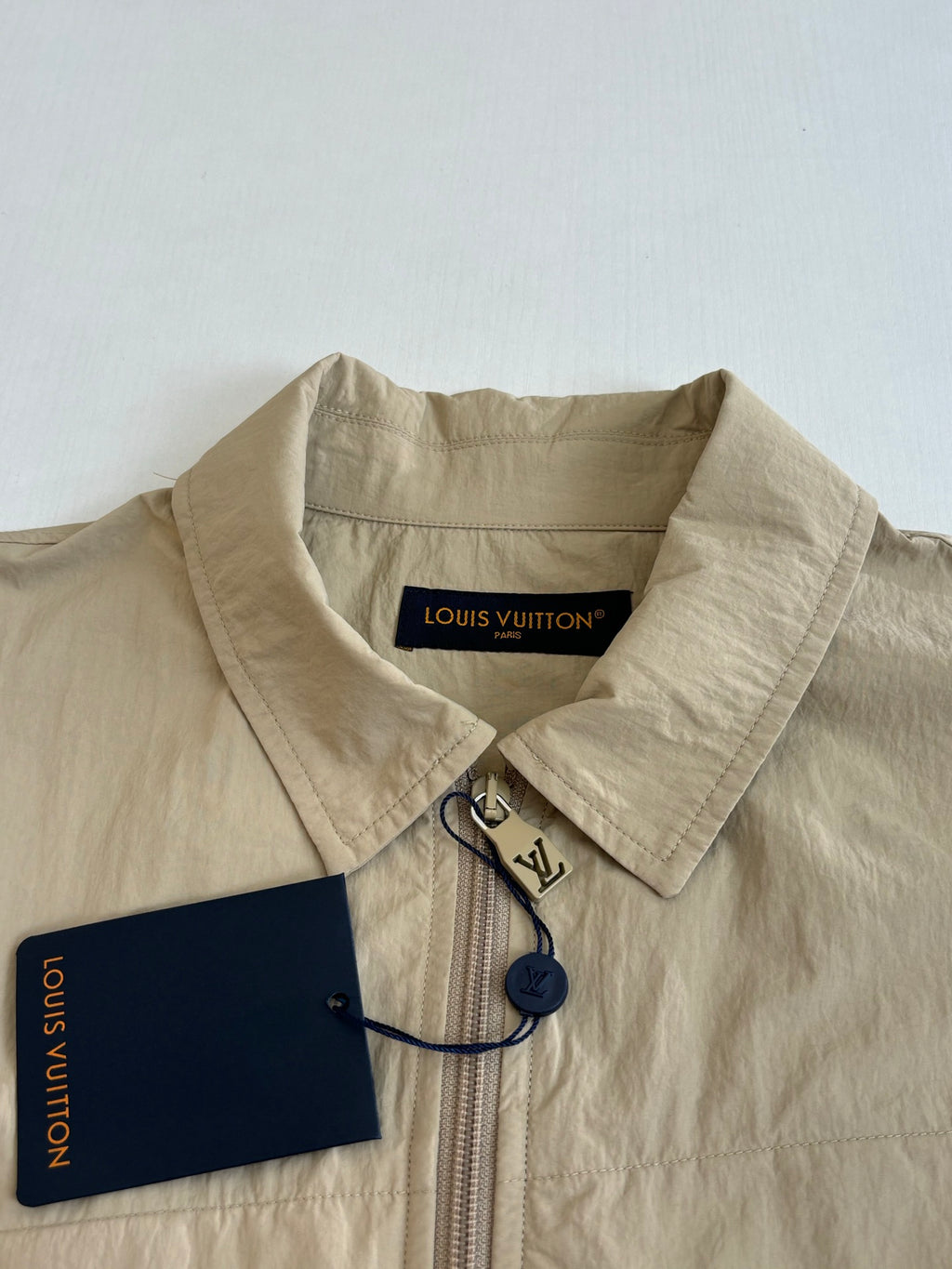 Beige Louis Vuitton jacket collar with front zipper and attached hangtag