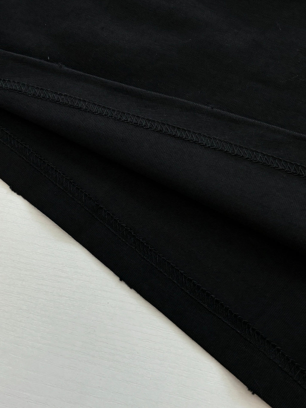 Balenciaga black T-shirt hem stitching detail, laid flat