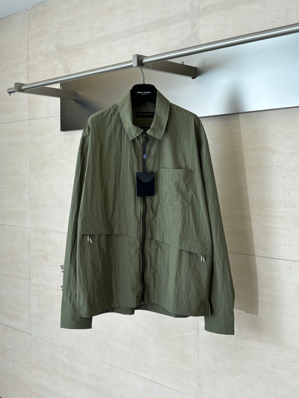 Olive green long-sleeve jacket with button-front placket and chest pockets.