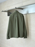 Olive green jacket, back view, with stand collar and partial seam detailing.