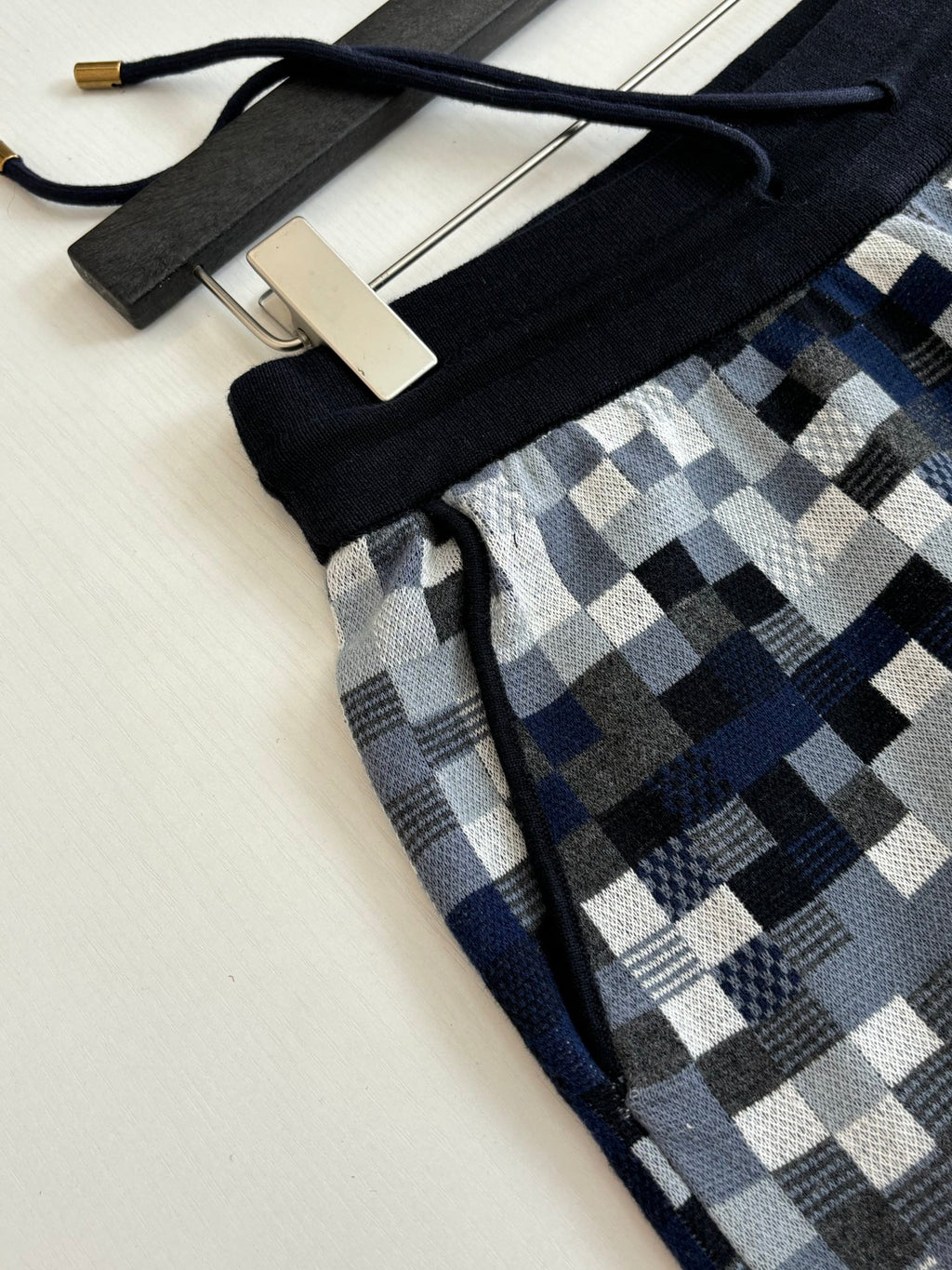 Louis Vuitton drawstring shorts detail: black waistband and blue-gray check fabric