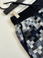 Louis Vuitton drawstring shorts detail: black waistband and blue-gray check fabric