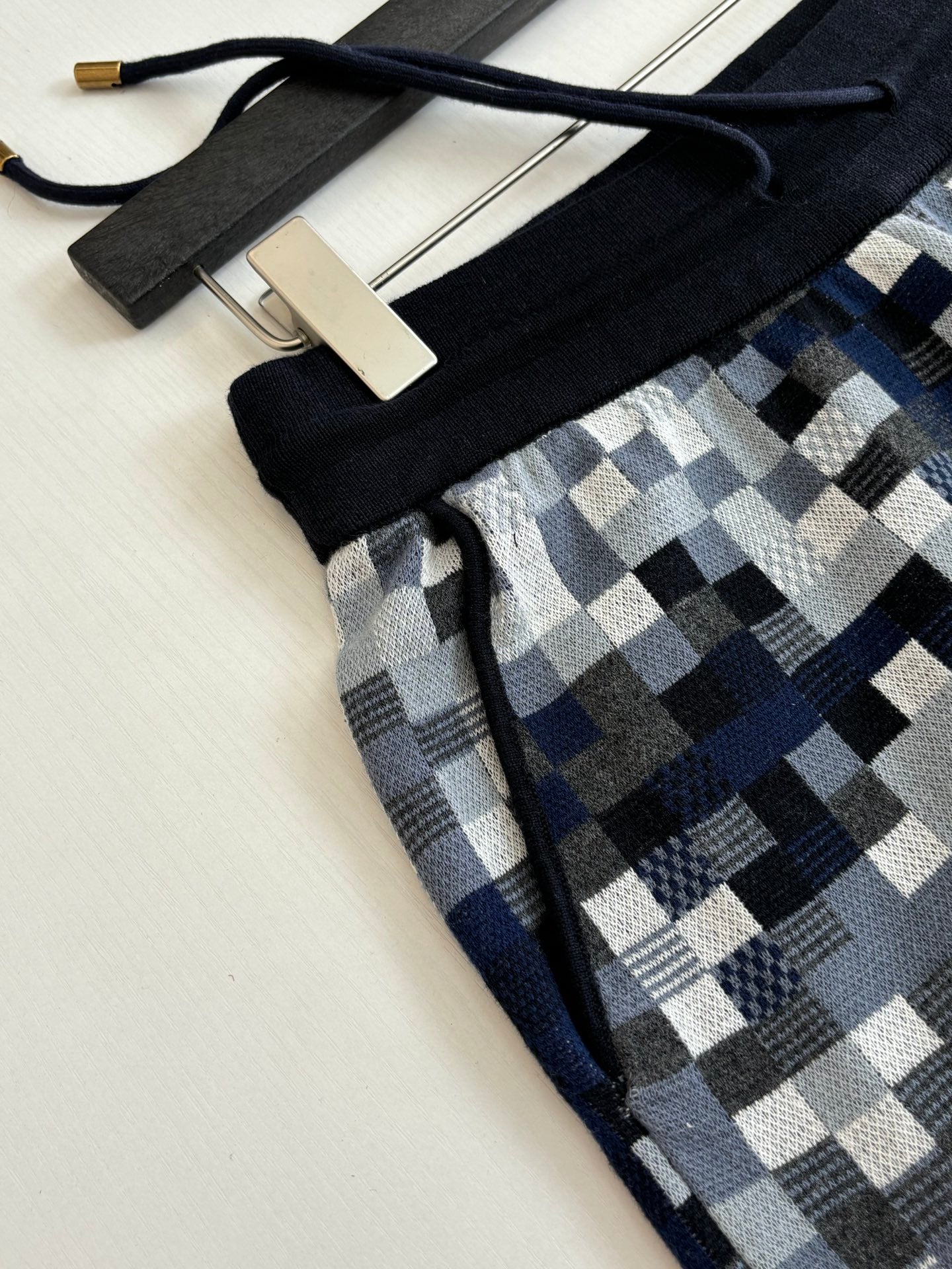 Louis Vuitton drawstring shorts detail: black waistband and blue-gray check fabric