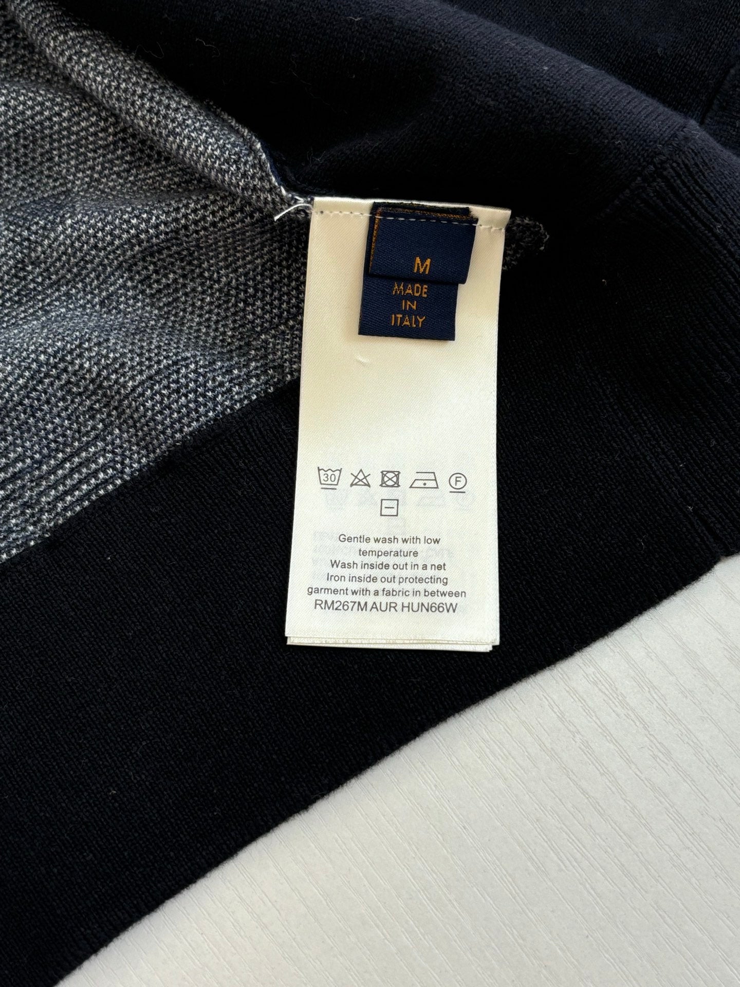 Louis Vuitton long garment with care label on dark textured fabric