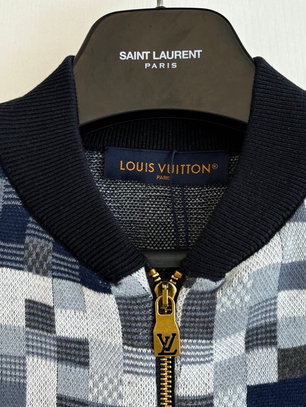 Knit sweater collar detail in blue-and-white check with black ribbed trim and zipper