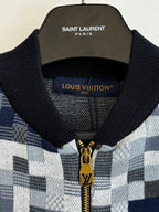 Knit sweater collar detail in blue-and-white check with black ribbed trim and zipper