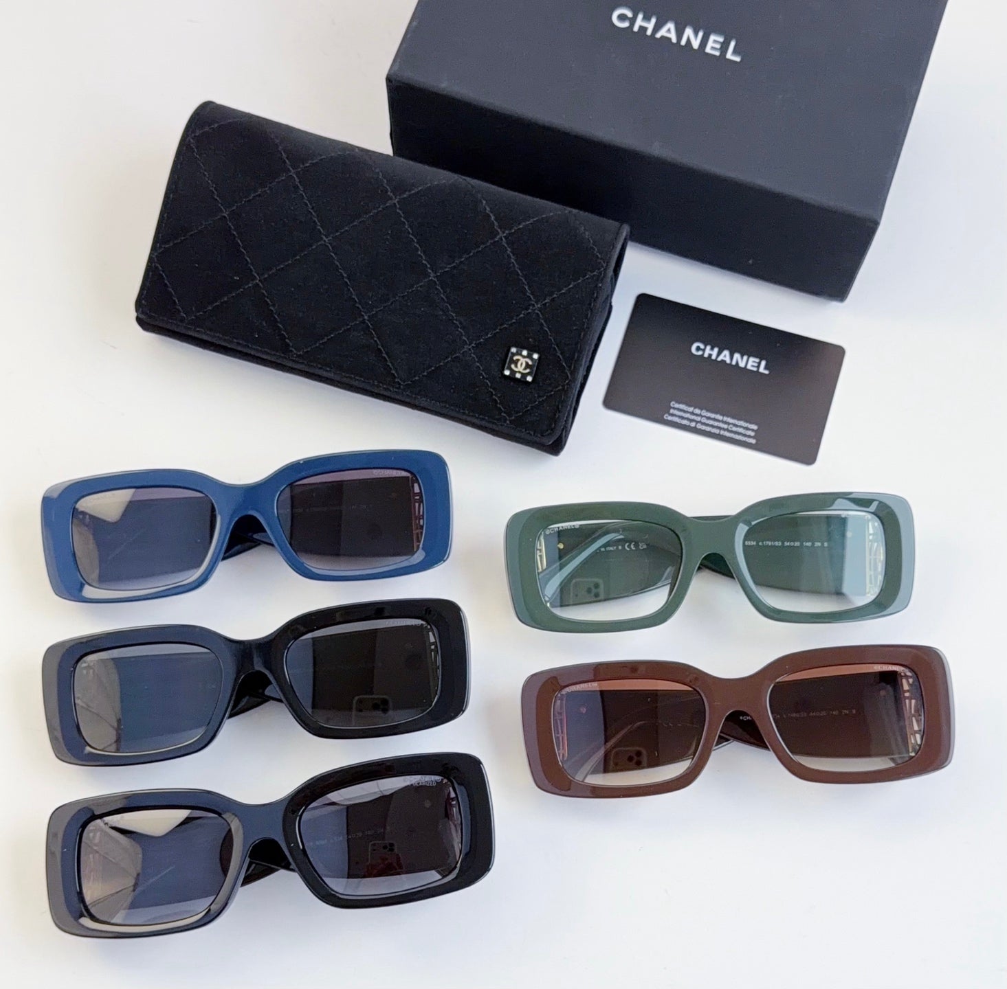 Set of five square sunglasses in blue, navy, green, and brown frames with tinted lenses