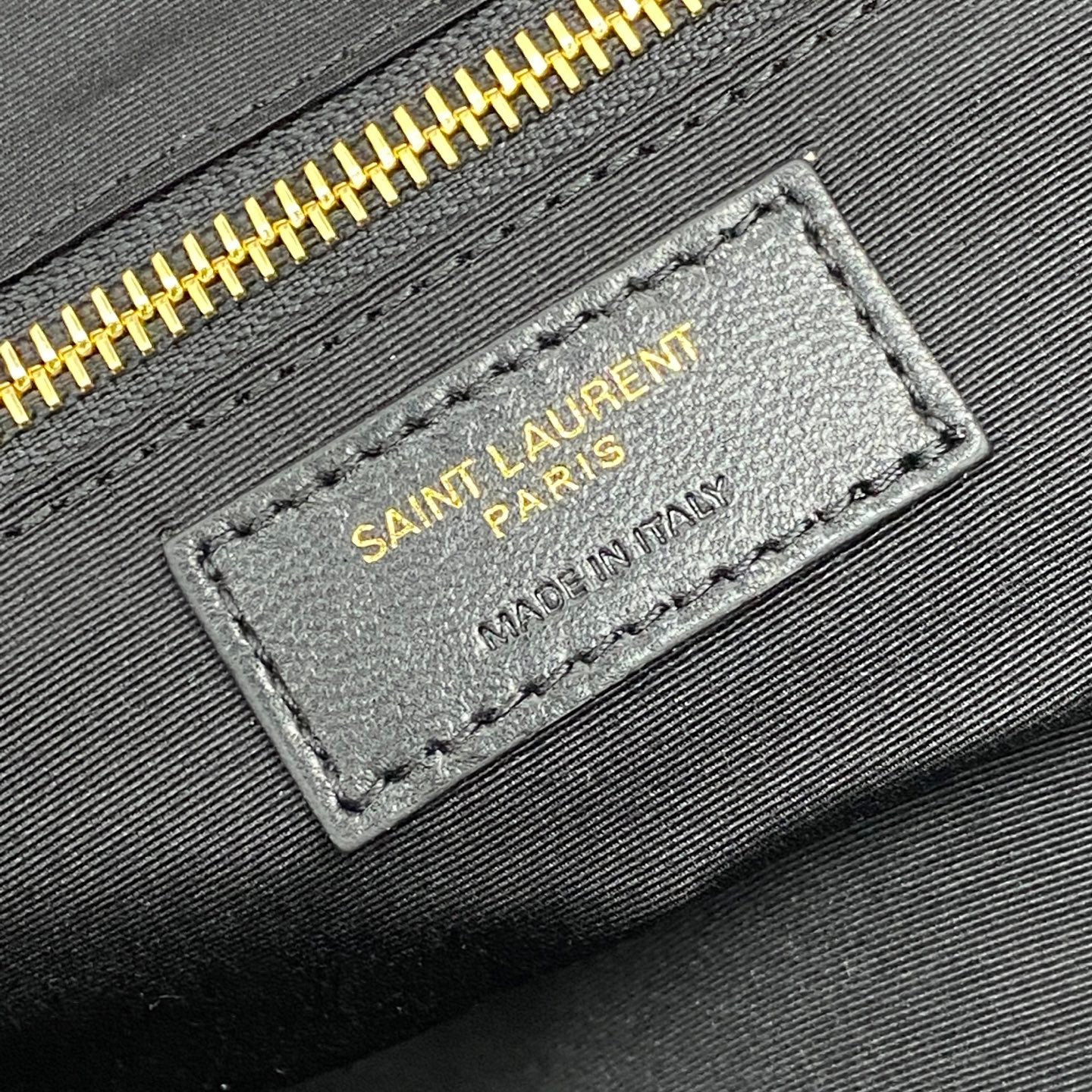 SAINT LAURENT PARIS fabric label with MADE IN ITALY text on black textile