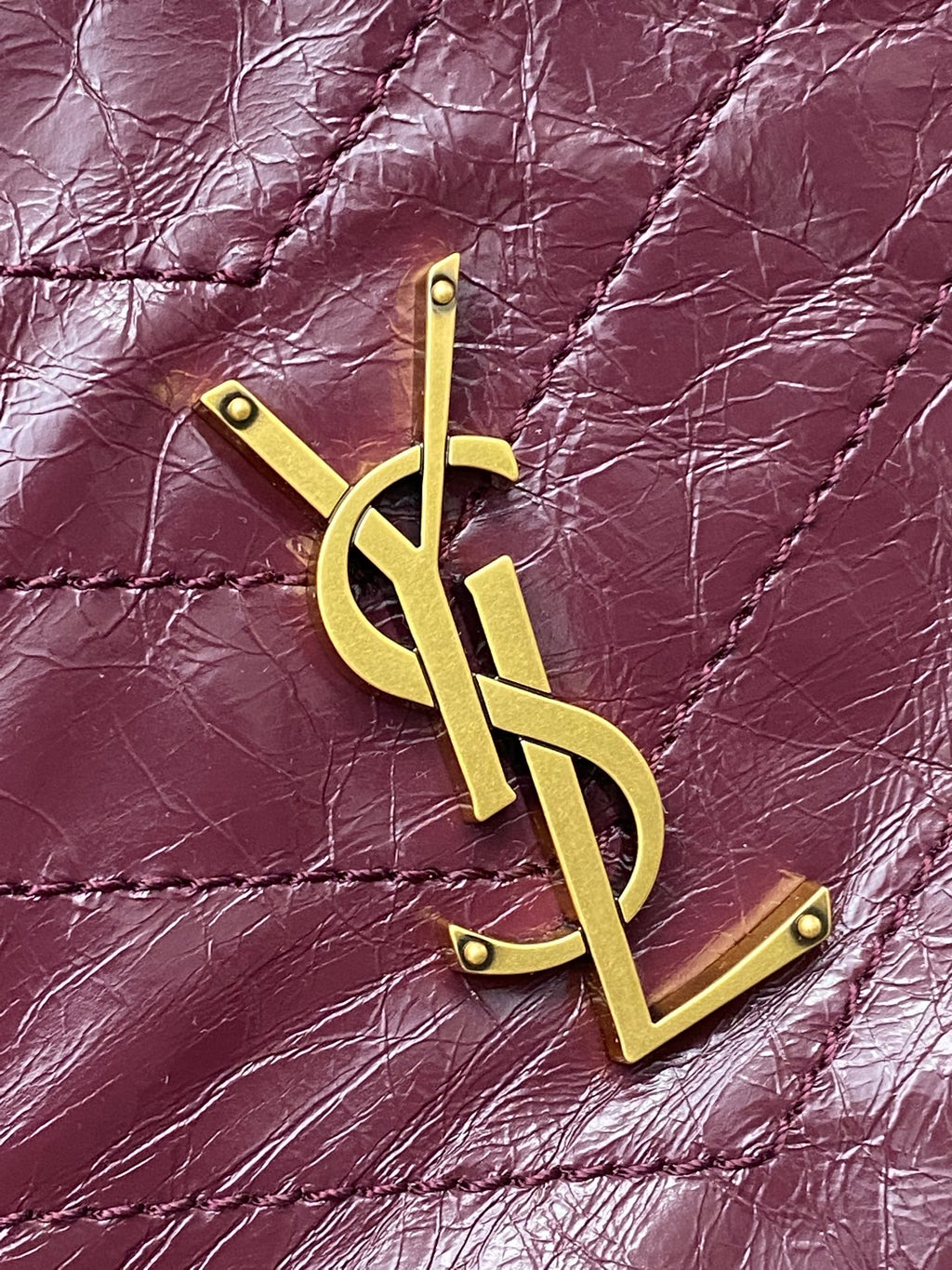 Burgundy leather with gold YSL monogram hardware on quilted surface