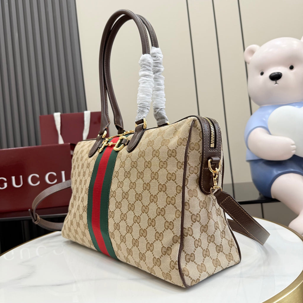 Gucci GG canvas handbag with red/green web stripe, dark brown handles, and shoulder strap.