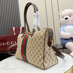 Gucci GG canvas handbag with red/green web stripe, dark brown handles, and shoulder strap.
