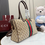 Gucci GG canvas satchel with dark brown handles, red/green stripe panel, crossbody strap.