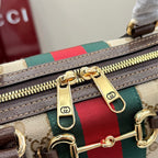 Gucci bag close-up of gold zipper and red/green web stripe on GG canvas with leather trim.