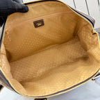 Gucci bag interior with tan patterned lining and zip-top opening, showing inner pocket area.