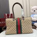 Gucci GG canvas tote bag with dark brown handles and red/green web stripe, gold hardware.