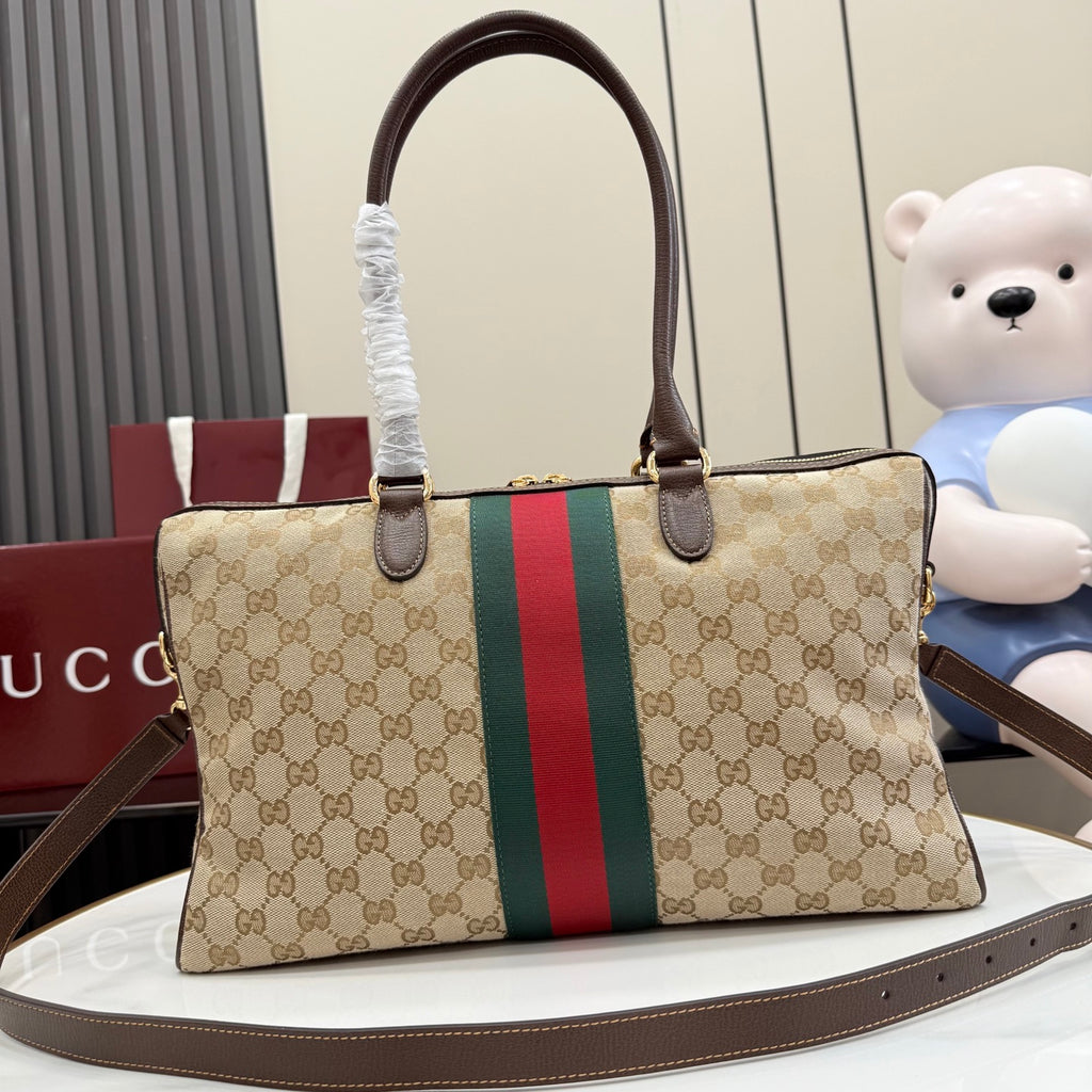 Gucci GG canvas tote bag with red/green web stripe and dark brown leather trim, side profile.