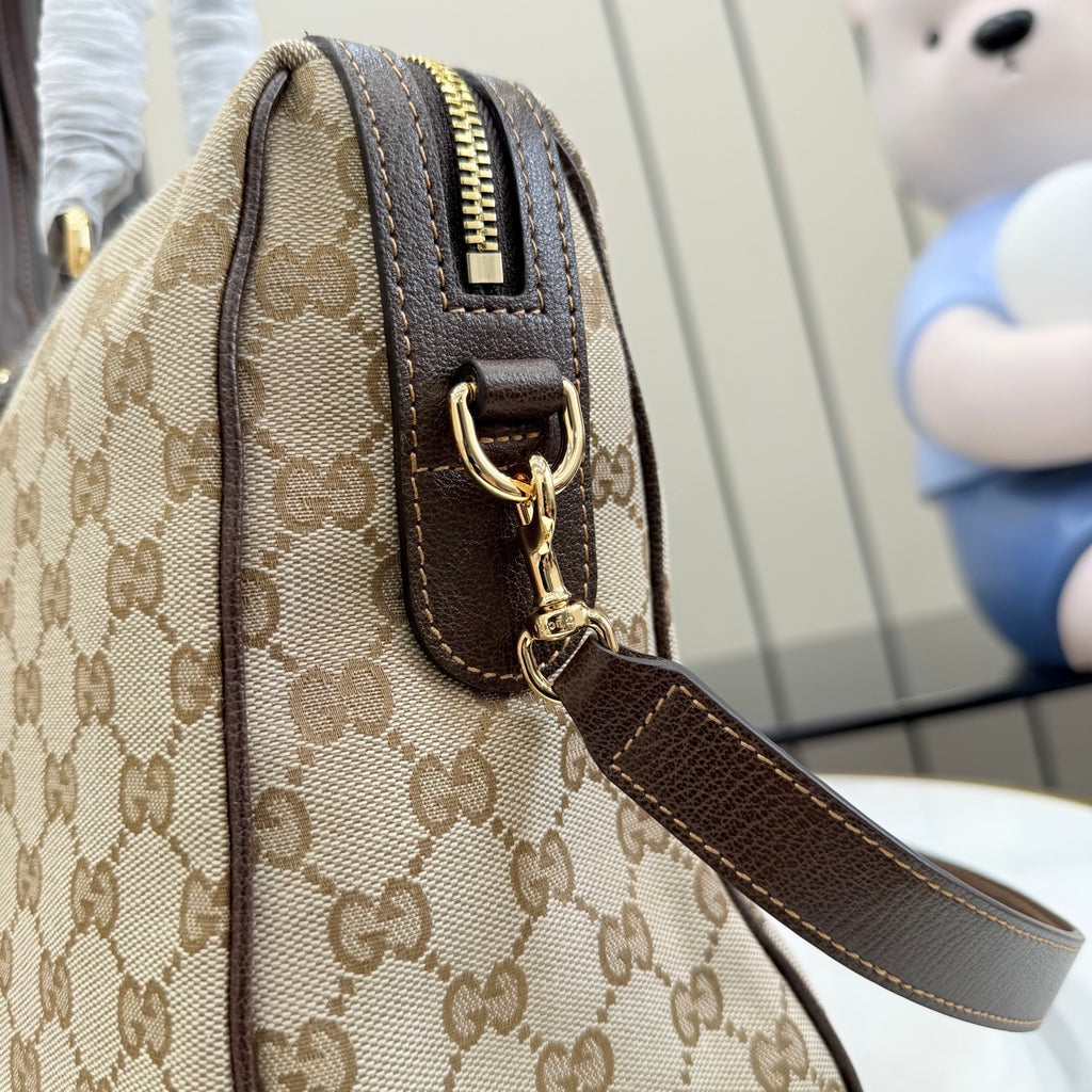 Gucci monogram canvas bag with brown leather trim, top zipper and shoulder strap