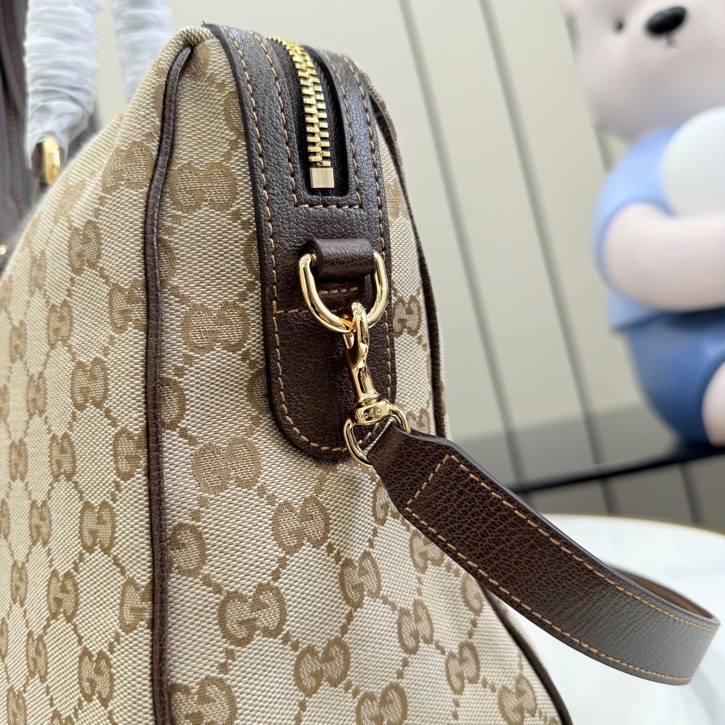 Gucci monogram canvas bag with brown leather trim, top zipper and shoulder strap