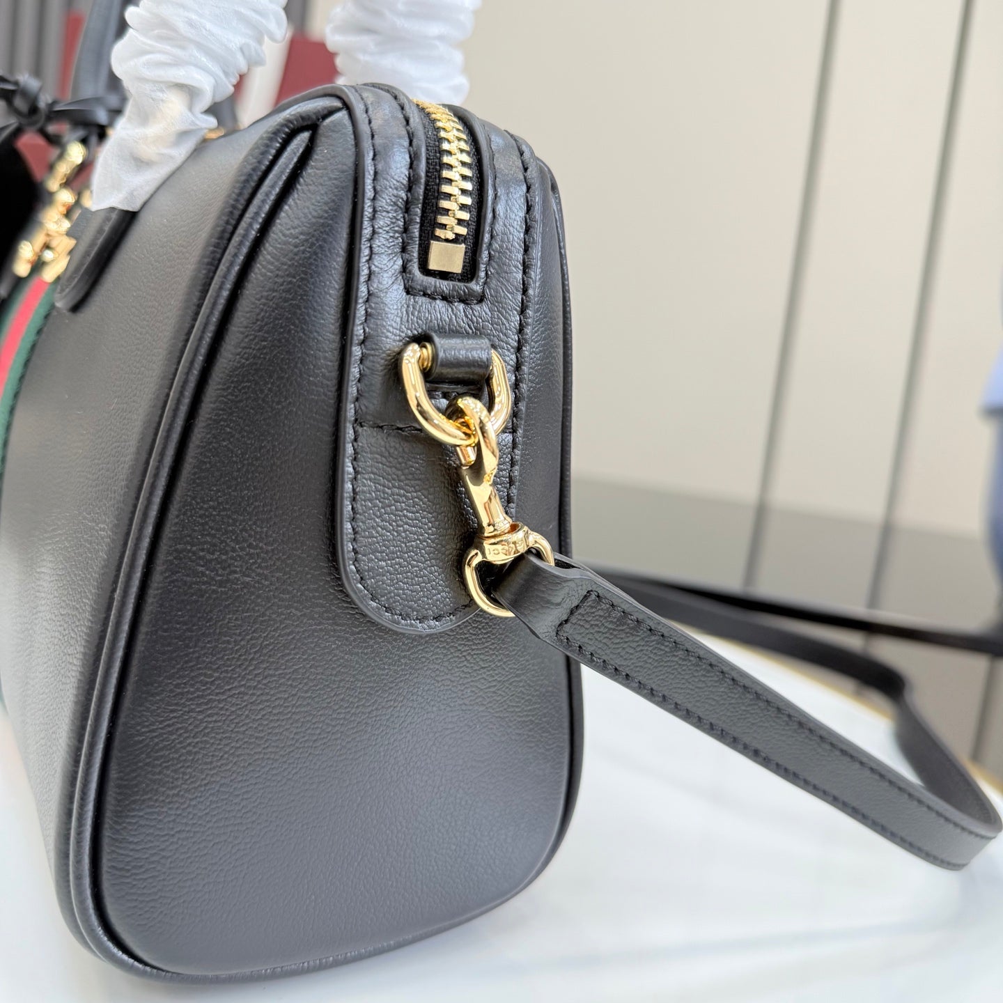 Gucci shoulder bag in black leather with gold zipper pull and chain strap