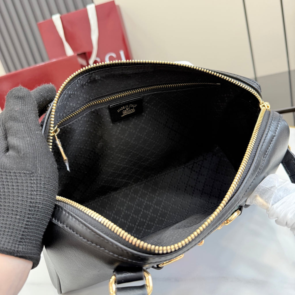 Black Gucci mini bag interior with fabric lining and gold-tone zipper trim.