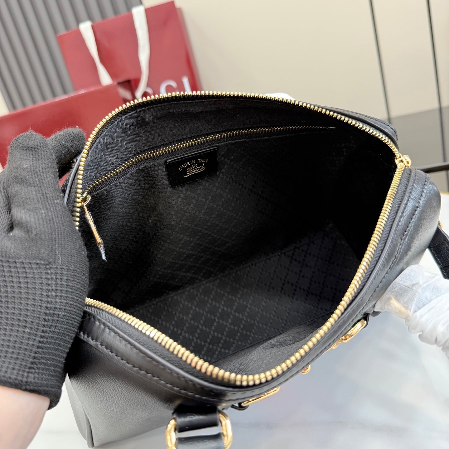 Black Gucci mini bag interior with fabric lining and gold-tone zipper trim.