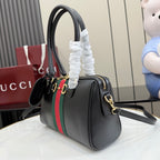 Black Gucci handbag with green-red stripe, gold-tone accents, and attached shoulder strap.