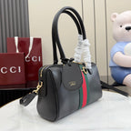 Black Gucci handbag with green-red web stripe, side strap, and gold-tone trim.