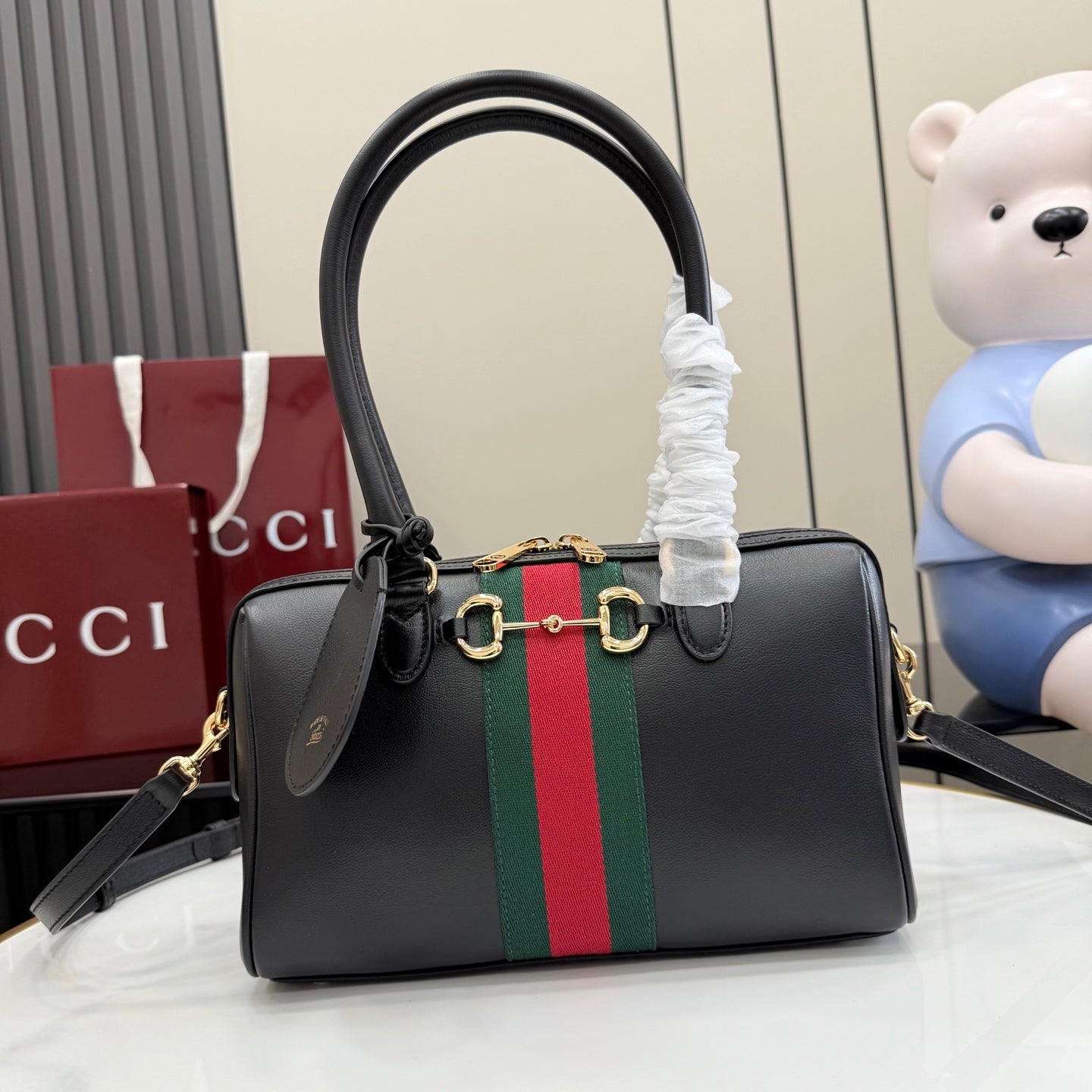 Black Gucci handbag with top handles, green-red stripe and gold-tone hardware.