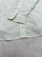 Light blue striped shirt cuff with button and folded sleeve detail
