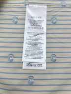 Gucci care label on light blue striped shirt fabric