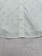 Light blue striped button-up shirt with vertical button placket and gold buttons
