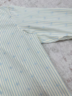 Light blue striped button-up shirt with small emblem pattern fabric detail