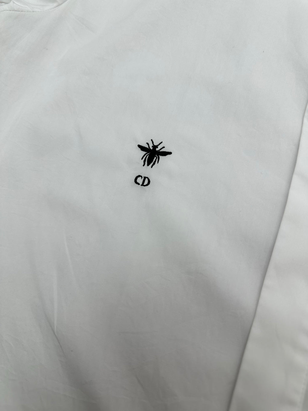 White shirt chest area with small black emblem logo
