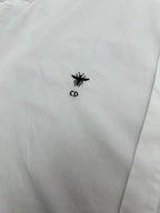 White shirt chest area with small black emblem logo