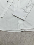 White shirt front with button placket and cuffs, small left chest logo