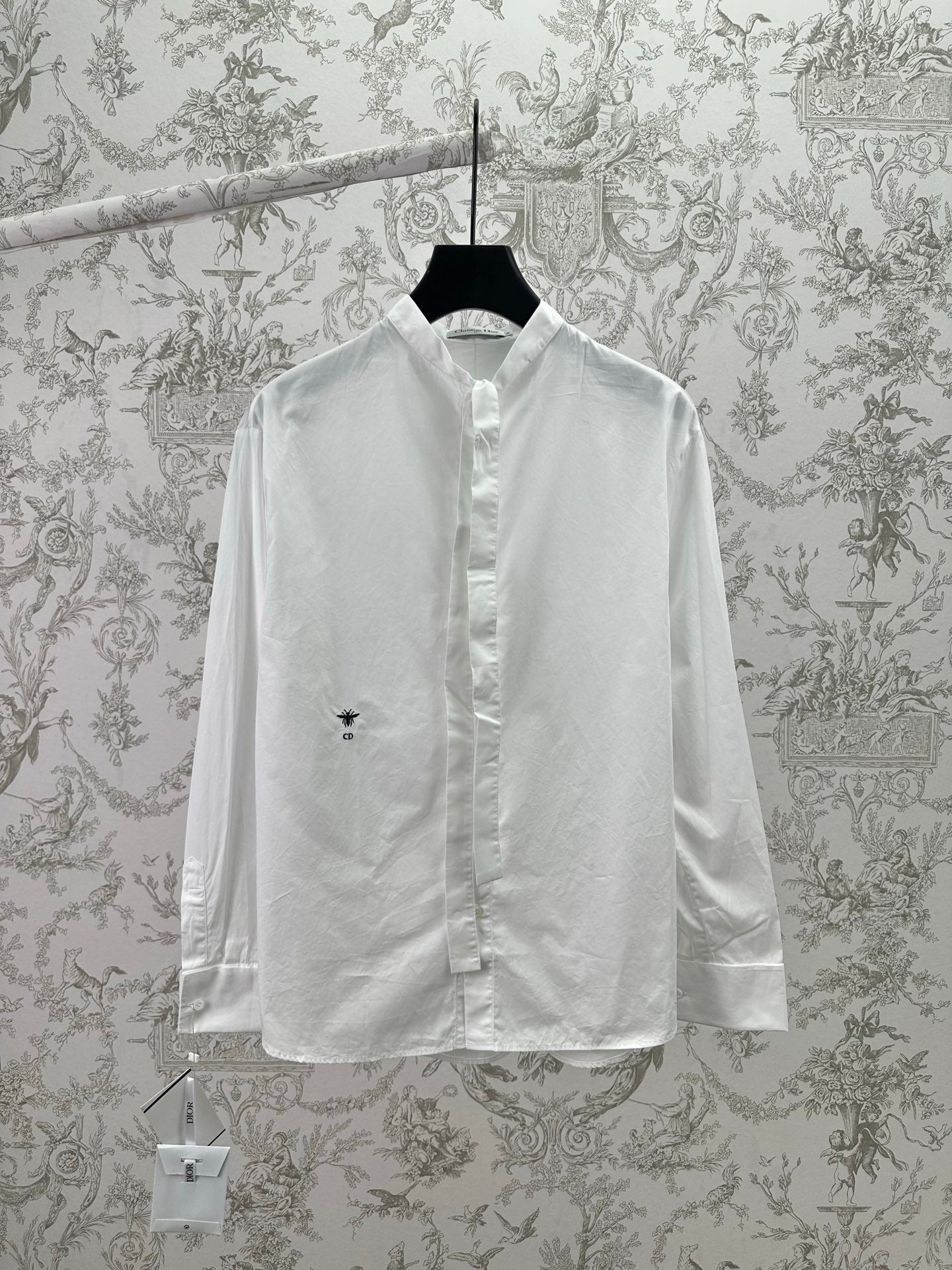 White long-sleeve button-up shirt with pointed collar and small chest logo