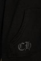 Black hoodie pocket corner with small gray embroidered monogram