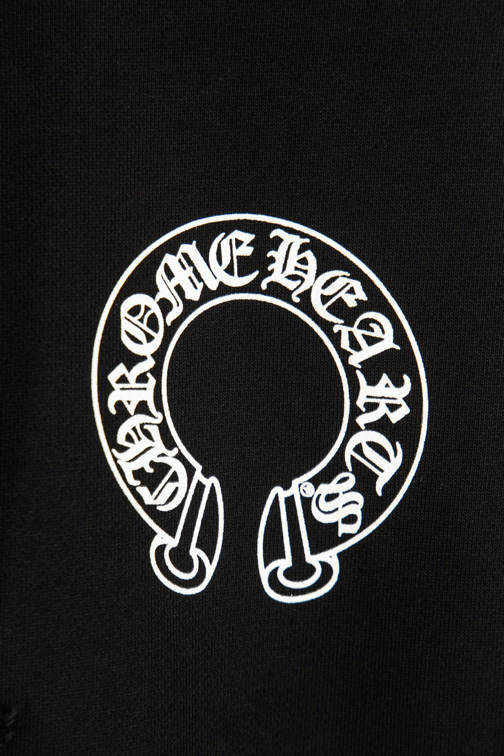 Black hoodie chest logo patch with white circular decorative graphic