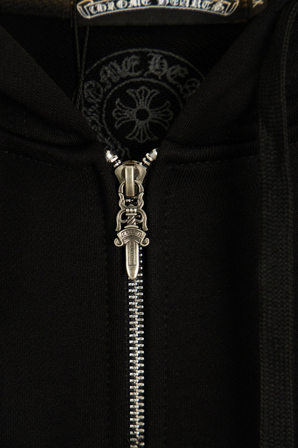 Black hoodie zipper and metal pull with embroidered collar graphic