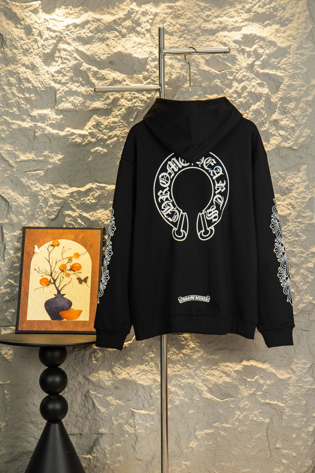 Black zip-up hoodie with hood and large center graphic; ornate sleeve prints