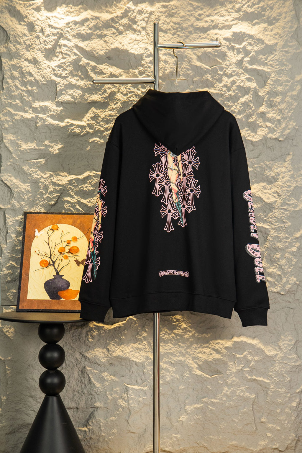 Black zip-up hoodie with large back graphic print and hood; sleeve side embroidery.