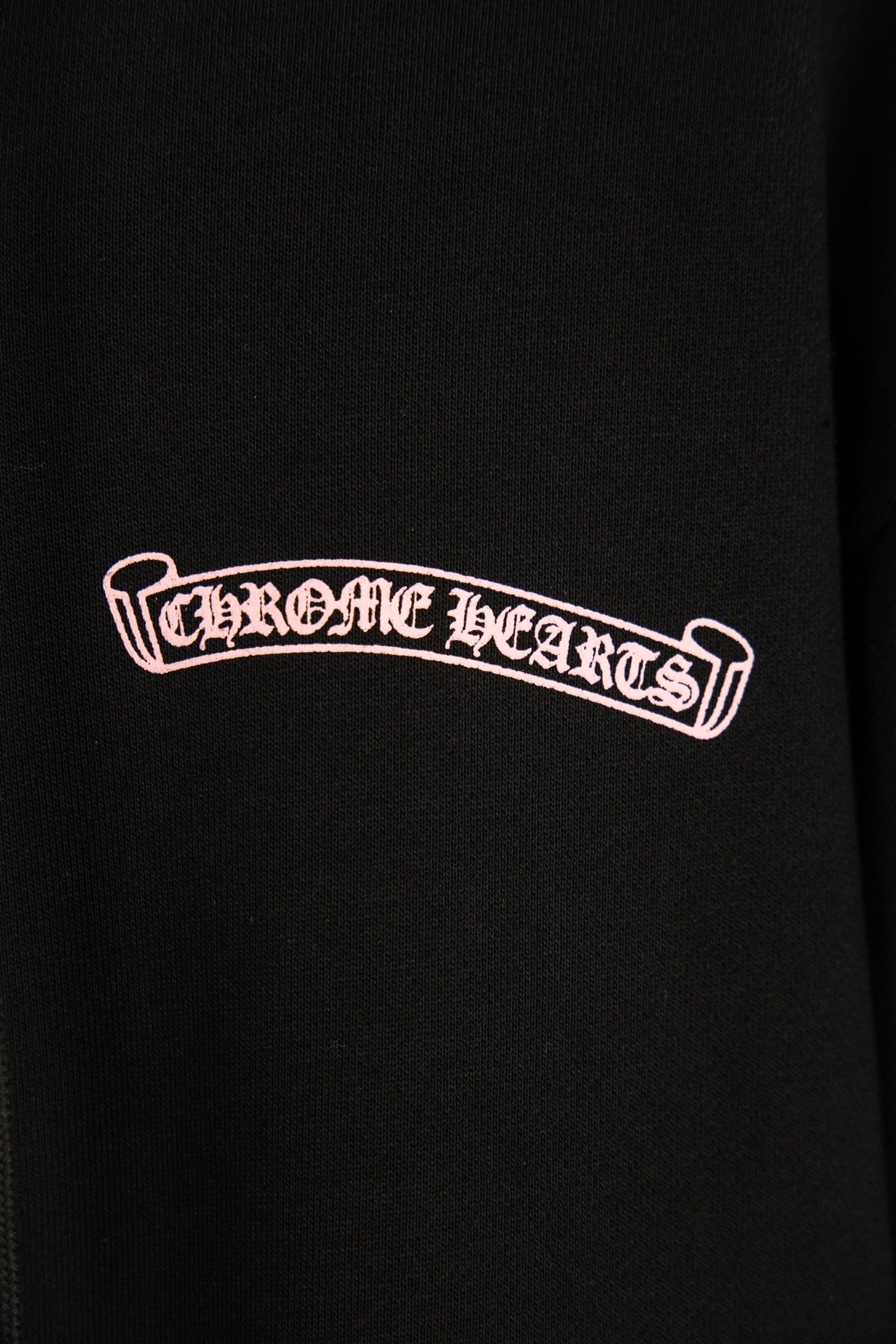 Black hoodie with small outlined logo print on left chest.