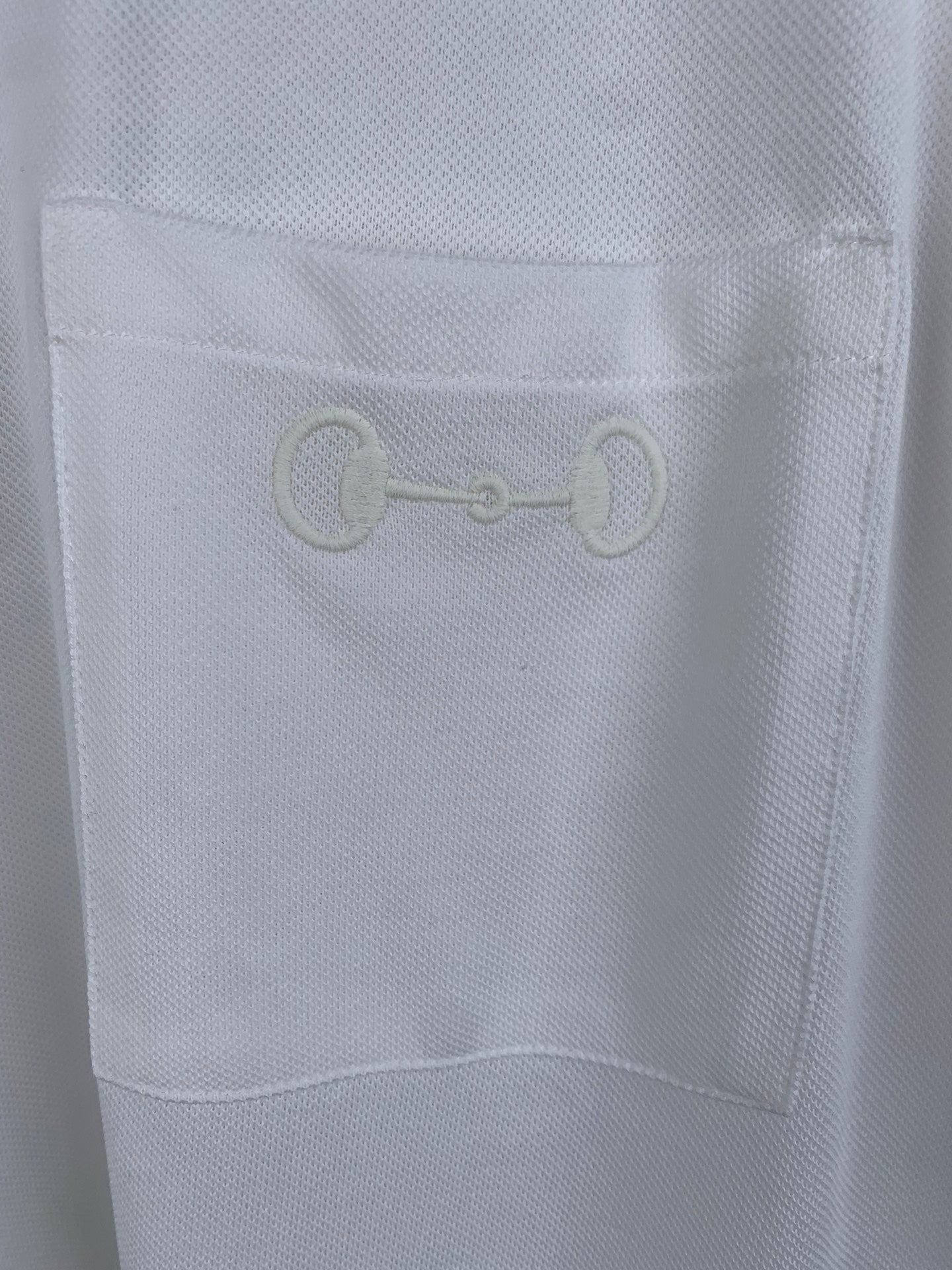 Gucci white T-shirt fabric with embroidered chain-link logo on chest