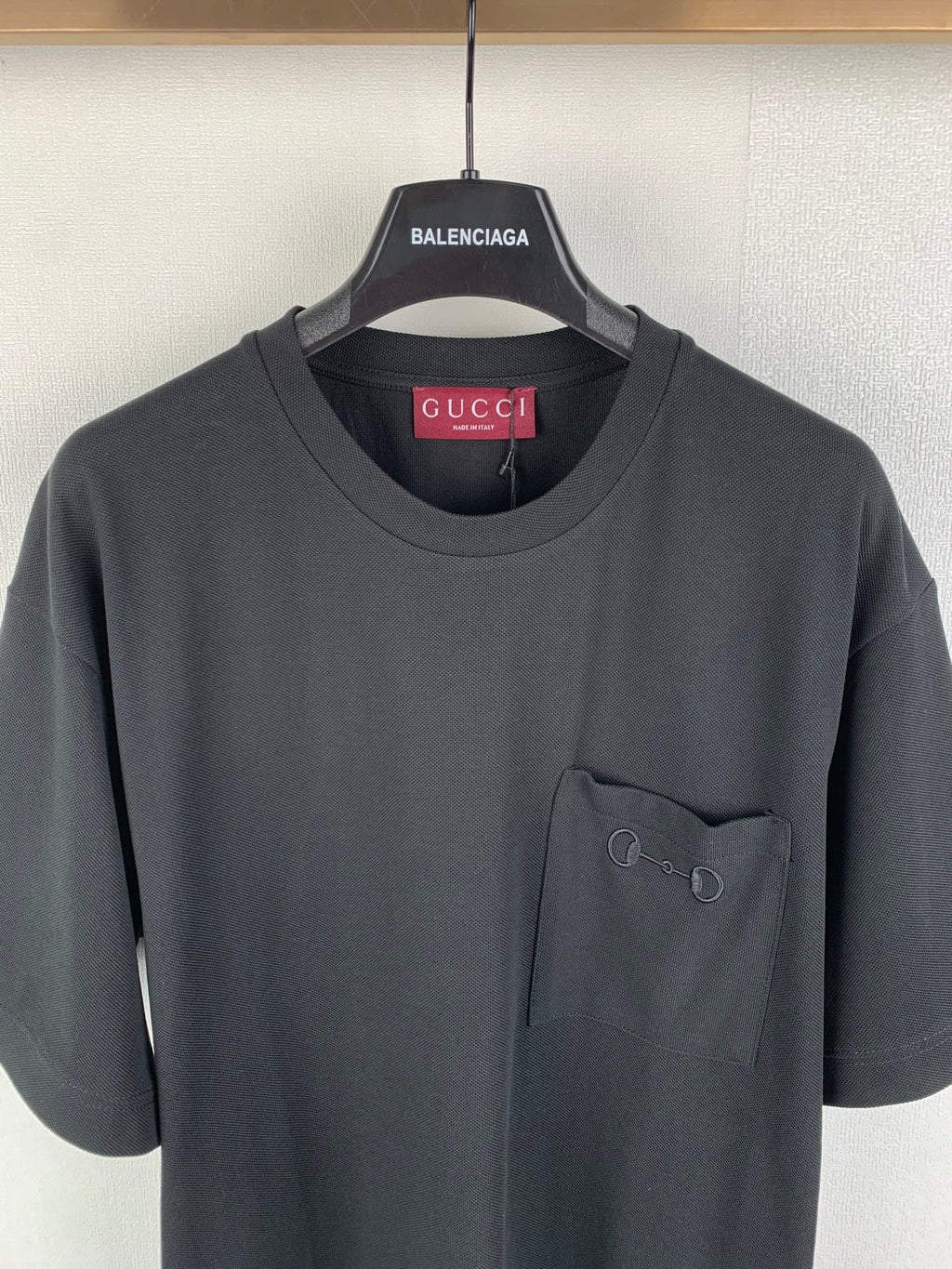 Dark charcoal crew-neck T-shirt with small chest pocket and visible seams