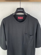 Dark charcoal crew-neck T-shirt with small chest pocket and visible seams