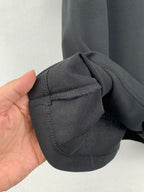 Chest pocket corner close-up on a dark crew-neck T-shirt with stitching